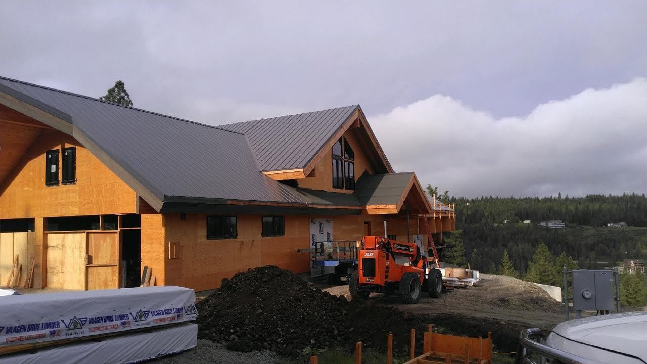 Timber-frame home under construction on a hillside