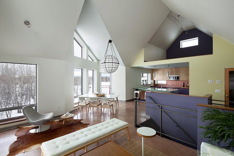 Open living and kitchen area with vaulted ceilings and large windows