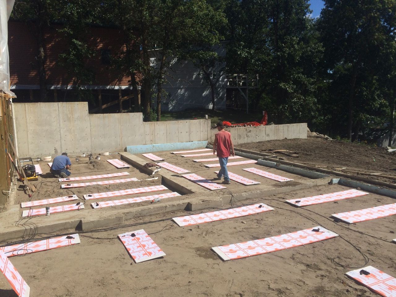 ThermaRay thermal mass panels laid out on sand inside the new foundation at the Lake Metigoshe cabin