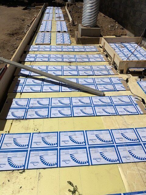 Snow melt heating panels laid on yellow insulation along the front walkway