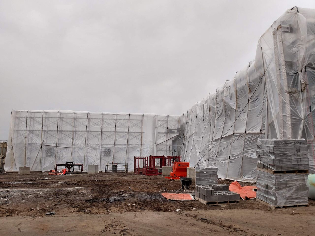 New building under construction, wrapped in plastic for winter work