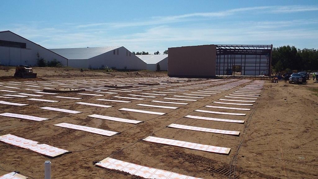Rows of ThermaRay heating panels laid across the ground of the Reeds Sports warehouse site