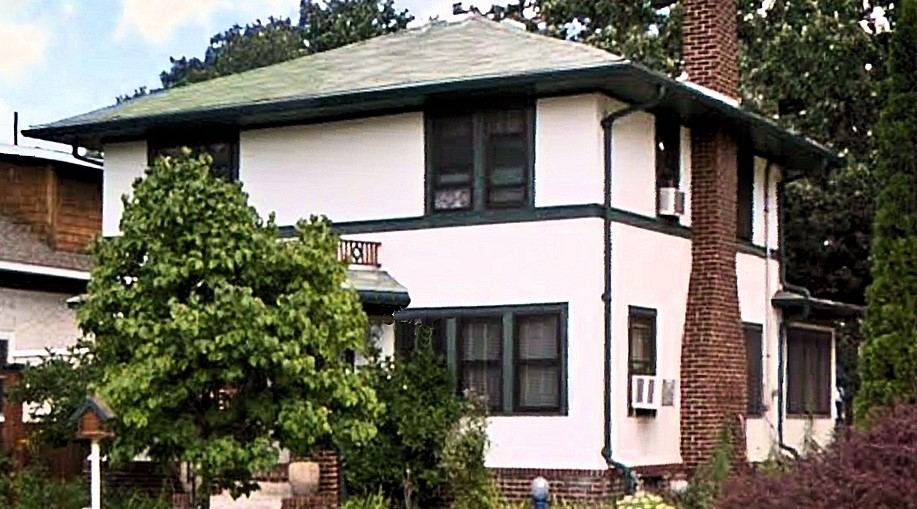 Two-story stucco home in St. Paul with green trim