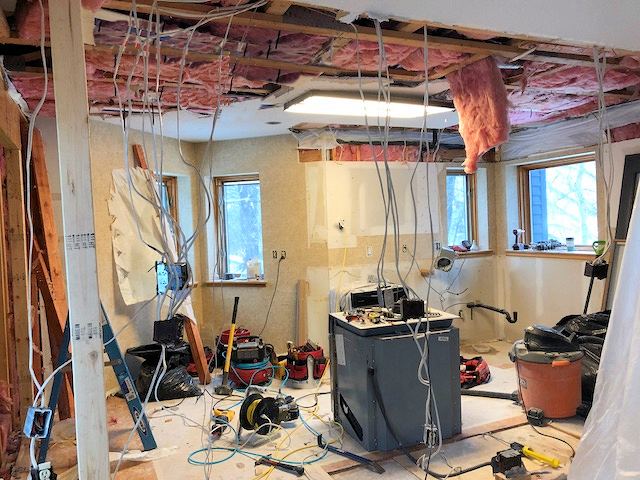 Kitchen with the ceiling opened up after storm damage, wires hanging