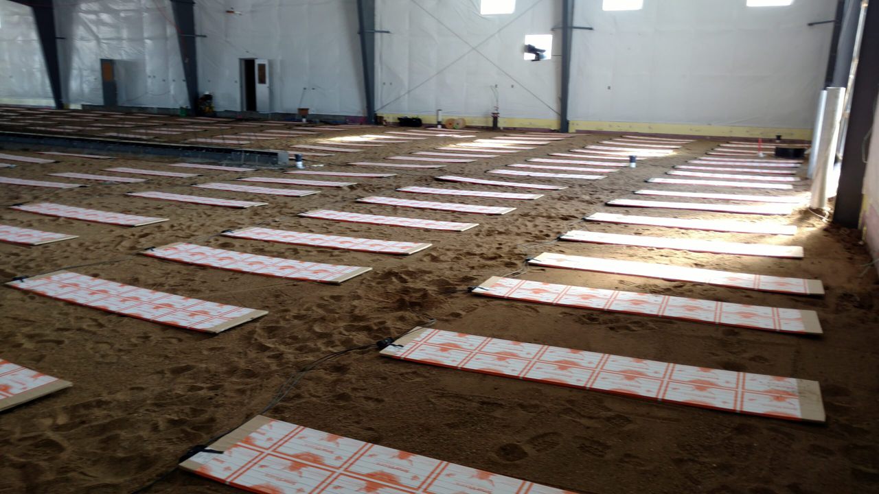 Thermal mass heating panels in rows on sand inside the Wadena utilities building
