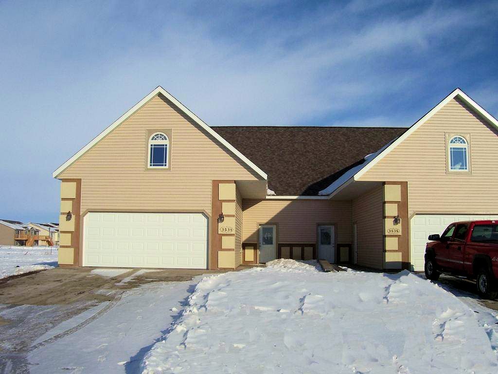 Two-story duplex with twin garages in West Fargo, North Dakota, in winter
